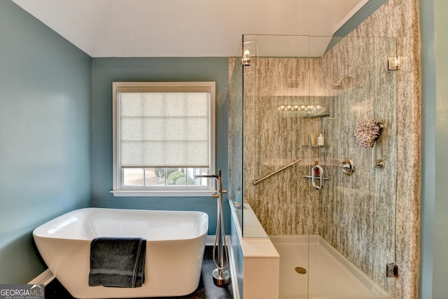 bathroom with a shower stall and a freestanding bath