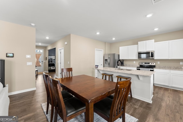 dining area with baseboards, dark wood finished floors, and recessed lighting