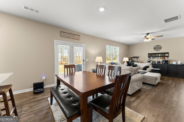 dining room with a ceiling fan, baseboards, visible vents, and dark wood-type flooring