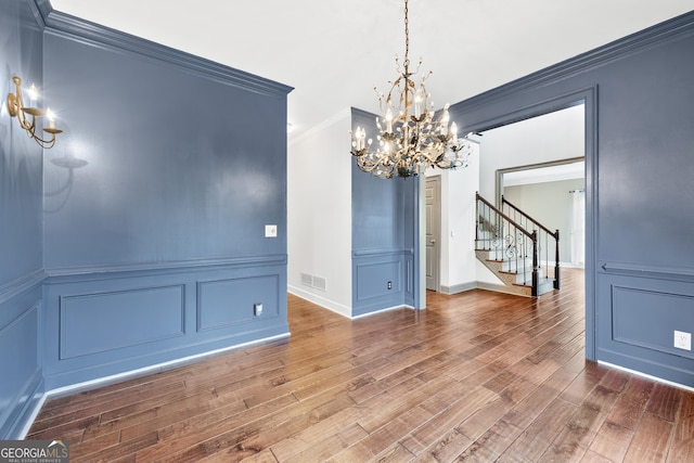 160 Deer Cliff Cv, Lawrenceville, GA 30043 - unfurnished dining area featuring a notable chandelier, stairs, a decorative wall, and wood finished floors