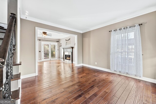 160 Deer Cliff Cv, Lawrenceville, GA 30043 - unfurnished living room featuring a glass covered fireplace, wood finished floors, baseboards, and ornamental molding