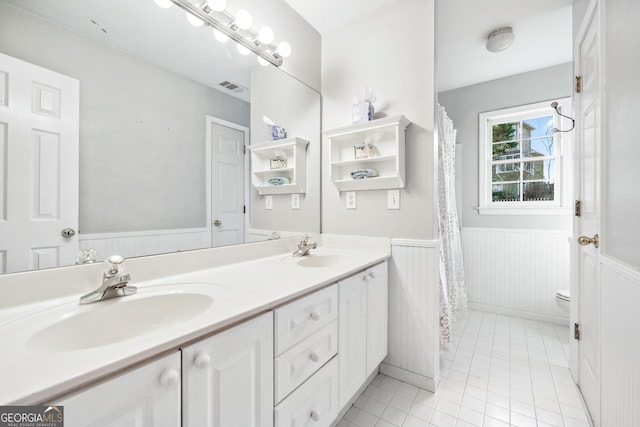 160 Deer Cliff Cv, Lawrenceville, GA 30043 - full bathroom featuring double vanity, visible vents, wainscoting, and a sink