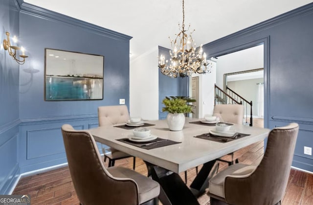 160 Deer Cliff Cv, Lawrenceville, GA 30043 - dining area featuring dark wood-style floors, an inviting chandelier, ornamental molding, stairs, and a decorative wall