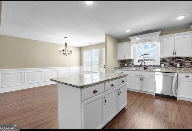 kitchen featuring a sink, stainless steel dishwasher, dark wood finished floors, and white cabinetry