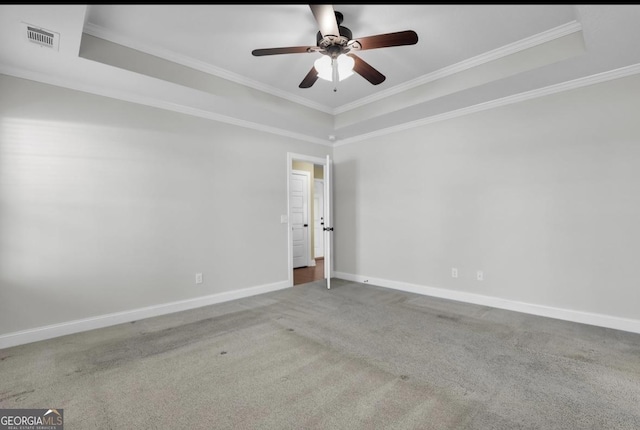 unfurnished room with ornamental molding, a tray ceiling, and visible vents