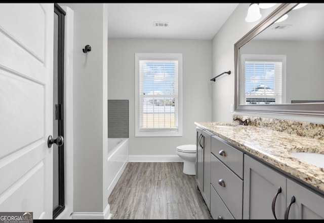 full bathroom with visible vents, a sink, toilet, and double vanity