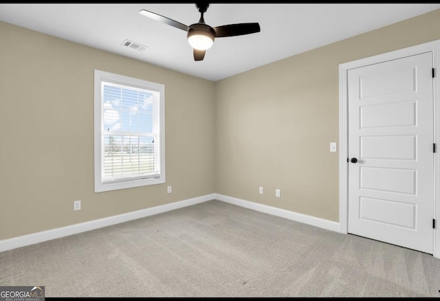 empty room featuring carpet floors, baseboards, visible vents, and ceiling fan