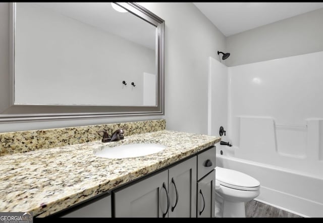 full bathroom with toilet, shower / washtub combination, wood finished floors, and vanity