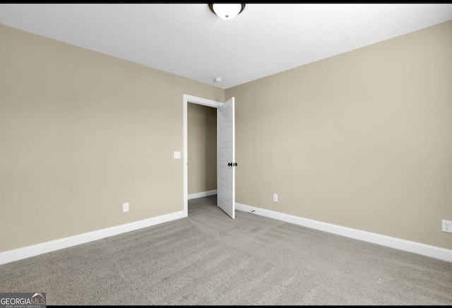 unfurnished bedroom featuring light colored carpet and baseboards