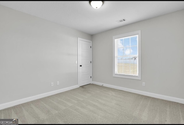 empty room with visible vents, baseboards, and carpet flooring