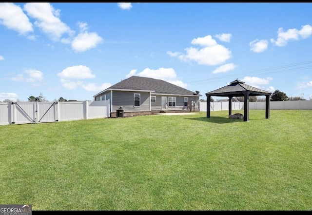 view of yard featuring a gate, a fenced backyard, and a gazebo