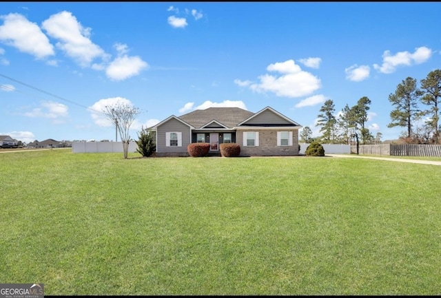 view of front of home featuring fence and a front lawn