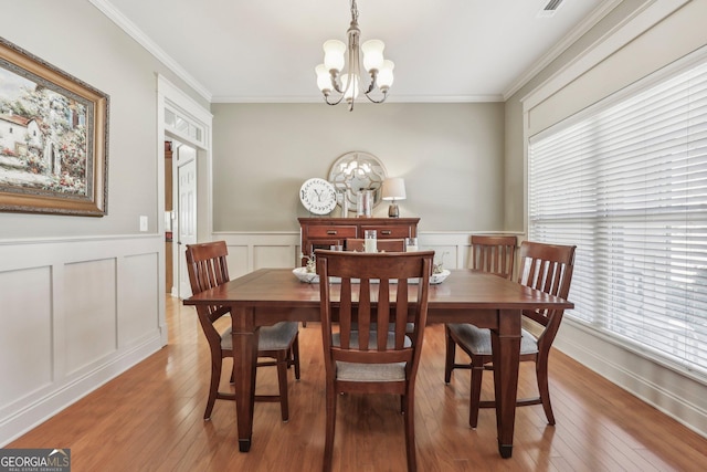 dining space with a chandelier, ornamental molding, and a wealth of natural light