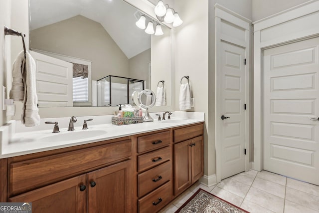 bathroom featuring vaulted ceiling, a stall shower, a sink, and tile patterned floors