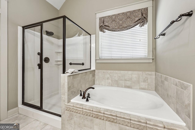 bathroom featuring tile patterned flooring, a shower stall, and a bath