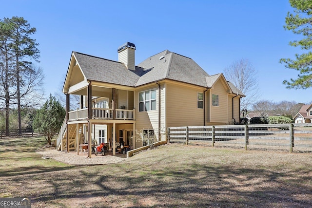 rear view of house with roof with shingles, a chimney, a patio area, a fenced backyard, and stairs