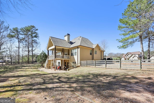 back of property featuring a chimney, a shingled roof, stairway, a fenced backyard, and a wooden deck