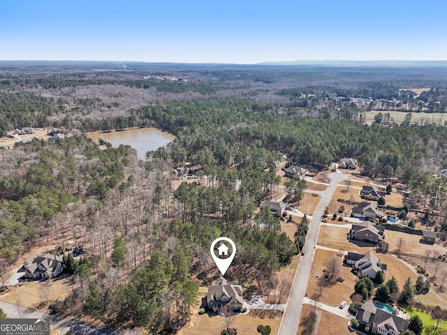 birds eye view of property with a water view and a view of trees