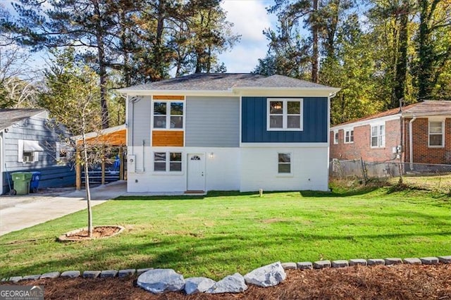 view of front of property featuring board and batten siding, a front yard, and fence