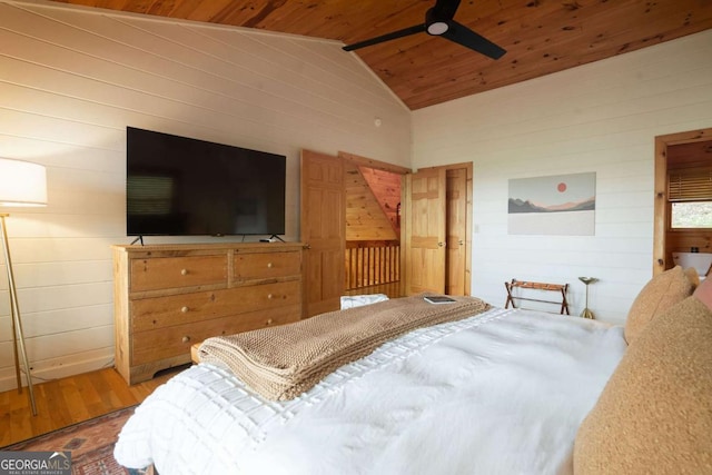 bedroom with wood walls, wood ceiling, vaulted ceiling, and wood finished floors