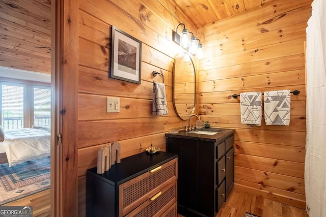 bathroom featuring wooden ceiling, wood walls, wood finished floors, and vanity