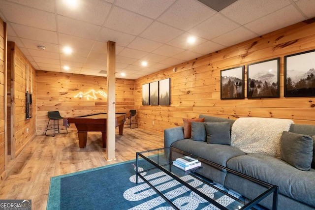 living area with pool table, light wood-type flooring, and wooden walls