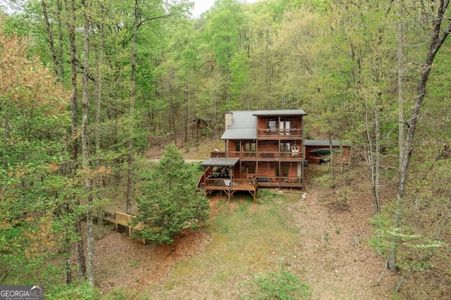 exterior space featuring a forest view and metal roof