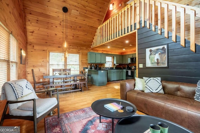 living area featuring high vaulted ceiling, wooden ceiling, wooden walls, stairs, and light wood-type flooring