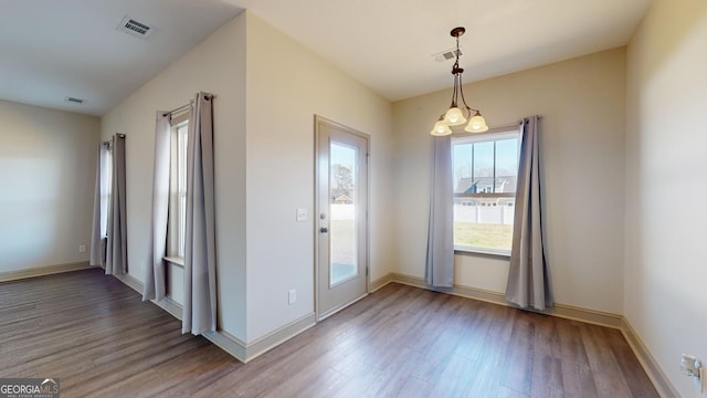 interior space featuring baseboards, visible vents, and wood finished floors