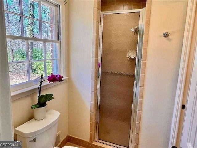 bathroom featuring a shower stall and toilet