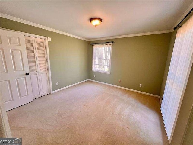 unfurnished bedroom featuring carpet floors, ornamental molding, a closet, and baseboards