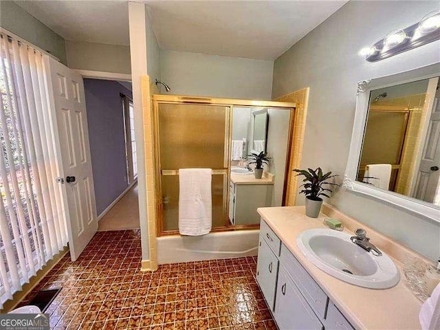 bathroom with vanity and bath / shower combo with glass door