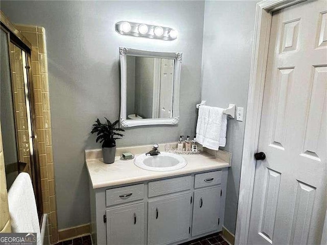 bathroom with a shower, vanity, and baseboards