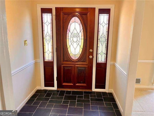 entrance foyer with stone finish flooring, visible vents, and baseboards