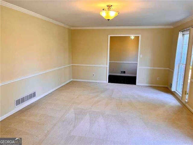 spare room with ornamental molding, carpet, visible vents, and baseboards