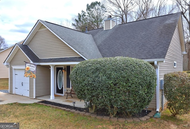 view of front of home with a garage, a shingled roof, and a chimney