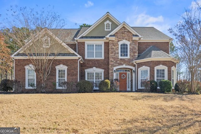 view of front of house with brick siding and a front lawn