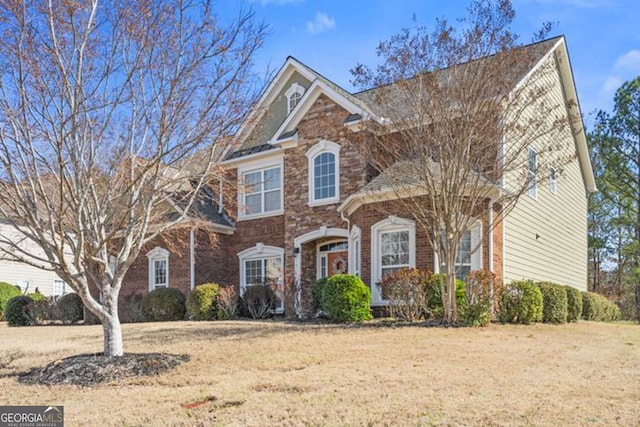 view of front of home with a front lawn and brick siding