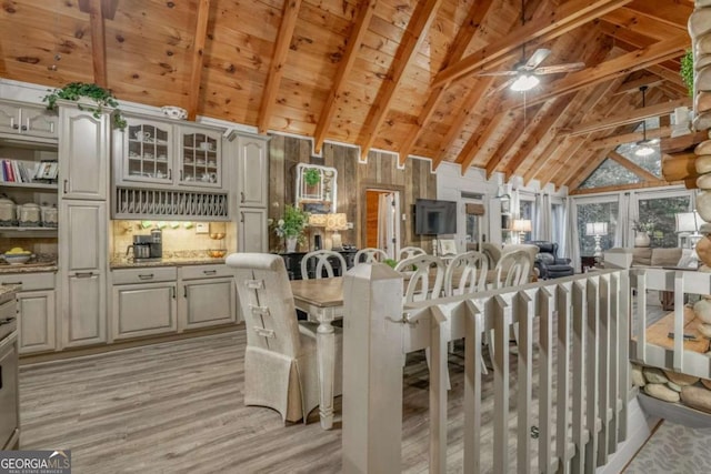 kitchen with ceiling fan, light stone counters, wood ceiling, beam ceiling, and light wood finished floors