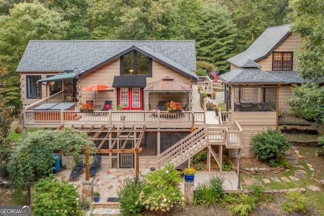 back of house with a deck, a shingled roof, and stairway