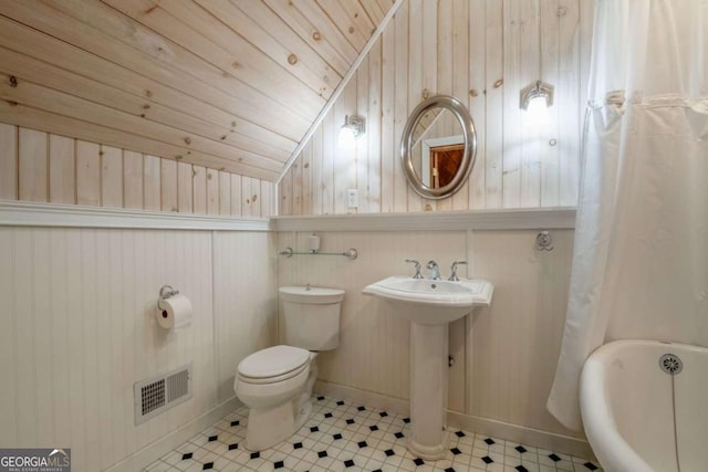 bathroom featuring wooden ceiling, toilet, a sink, visible vents, and vaulted ceiling