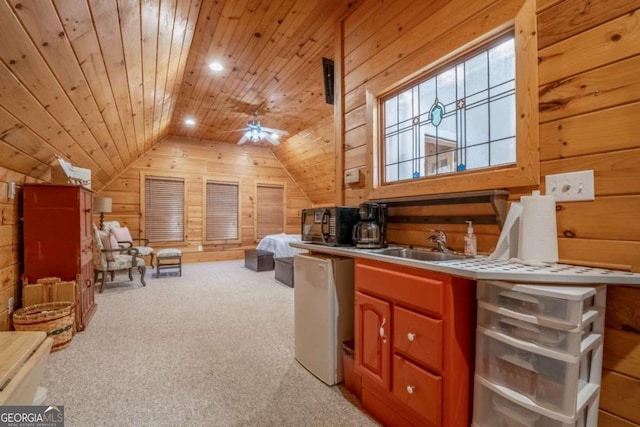 interior space with lofted ceiling, wooden ceiling, a sink, and wooden walls