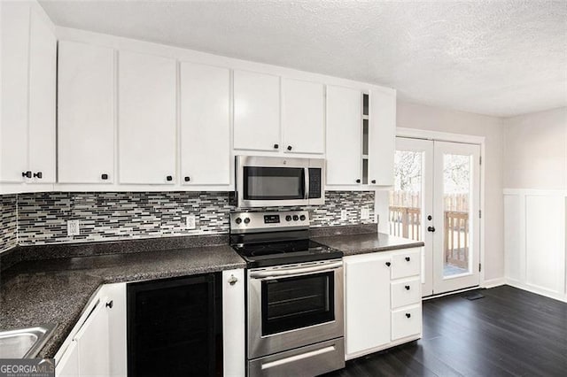 kitchen featuring dark countertops, white cabinetry, appliances with stainless steel finishes, and dark wood-style flooring