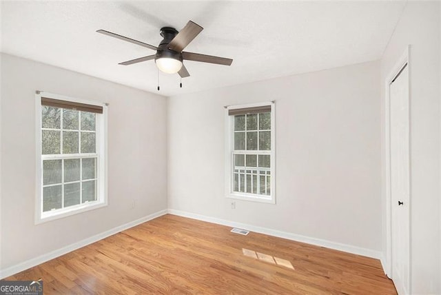 unfurnished bedroom featuring visible vents, light wood finished floors, and multiple windows