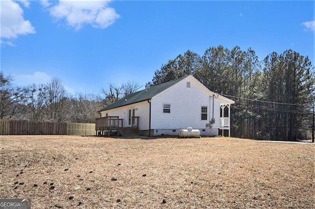 view of side of property with crawl space, fence, and a wooden deck