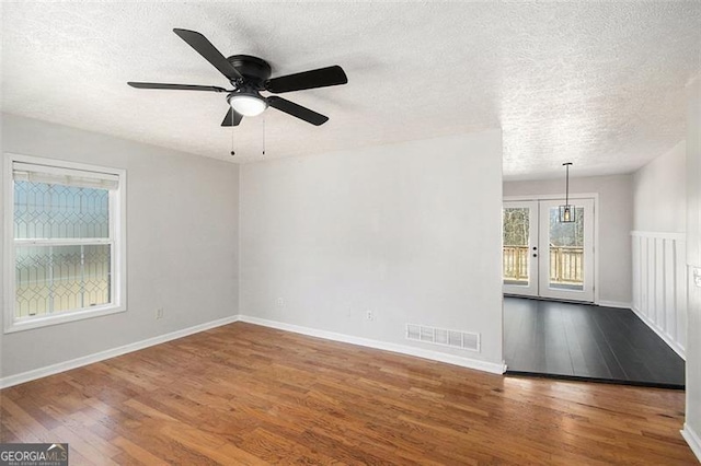 unfurnished room with visible vents, baseboards, and wood finished floors