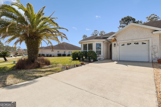 view of front of house featuring driveway, a front yard, an attached garage, and stucco siding