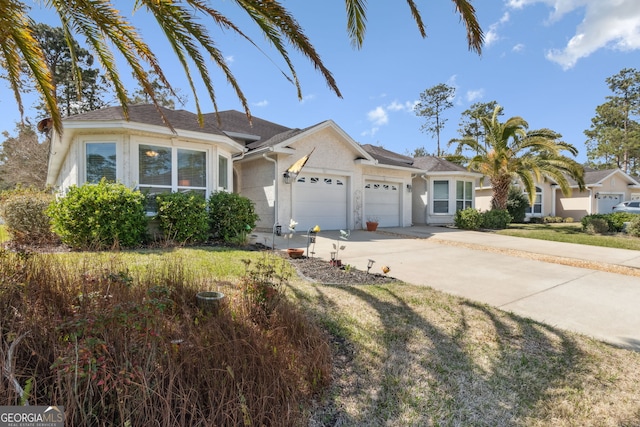 ranch-style home featuring a front yard, driveway, an attached garage, and stucco siding