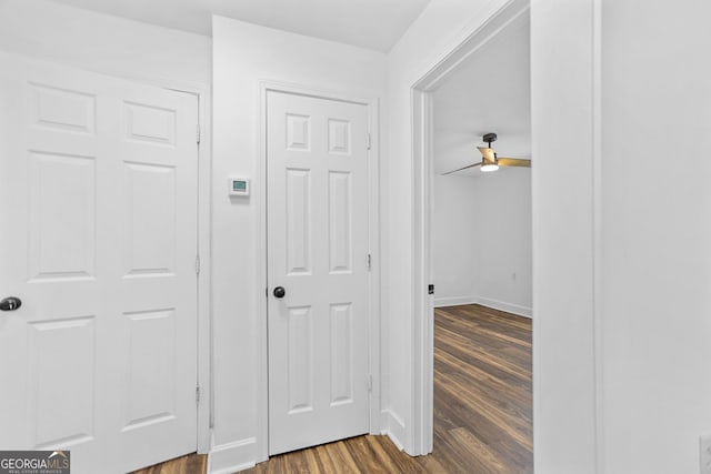 corridor with baseboards and dark wood finished floors