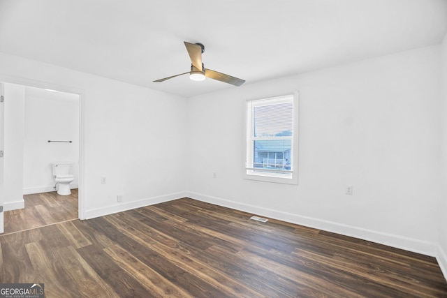 unfurnished bedroom featuring ceiling fan, ensuite bath, wood finished floors, and baseboards